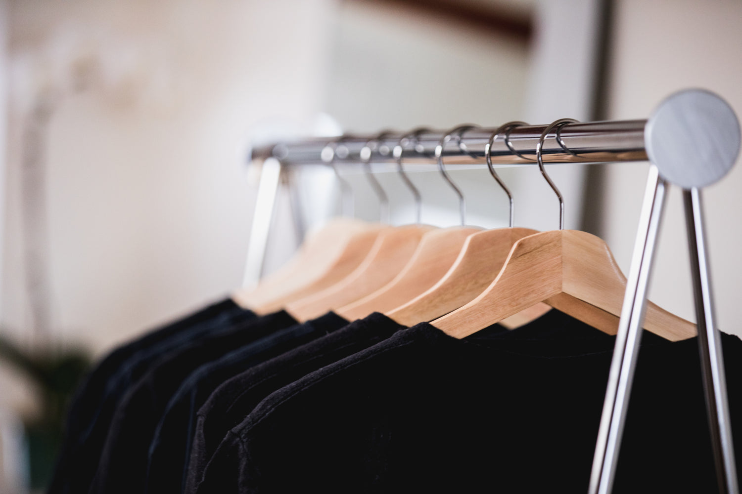 black clothing on a rack in a sunlit shop